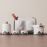Set of ceramic containers with mountain designs on a neutral background