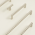 Silver beaded strands on a light beige background