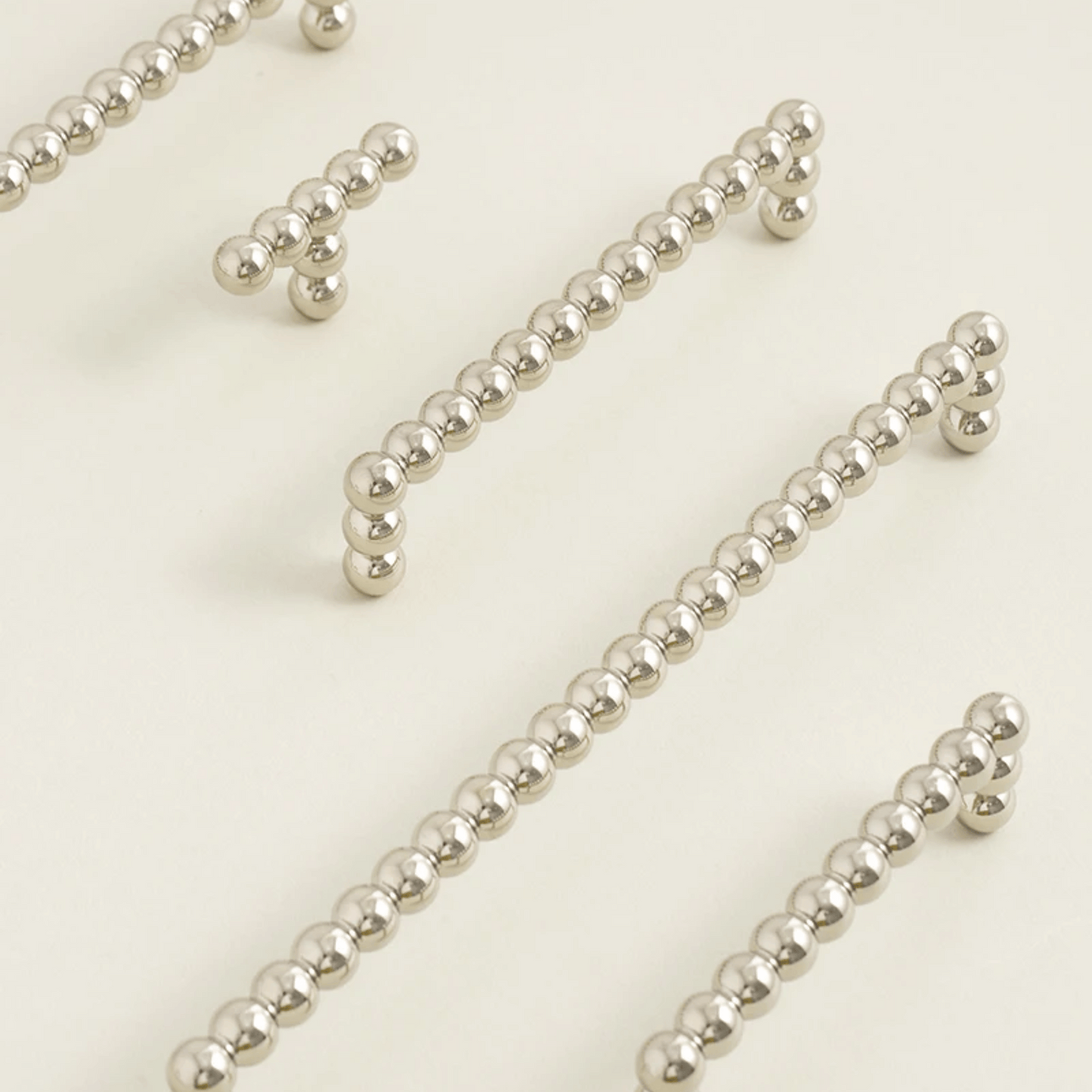 Silver beaded strands on a light beige background