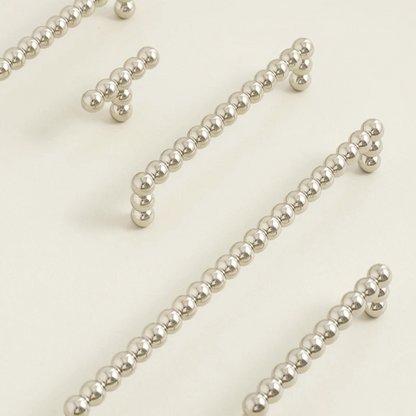 Silver beaded strands on a light beige background