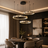Modern dining room with round table and chairs, featuring ceiling lights.