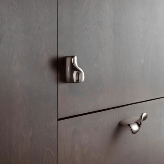 Metallic cabinet handles on a gray wooden cabinet