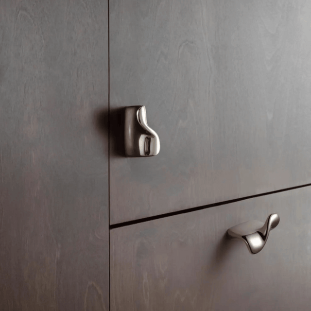 Metallic cabinet handles on a gray wooden cabinet
