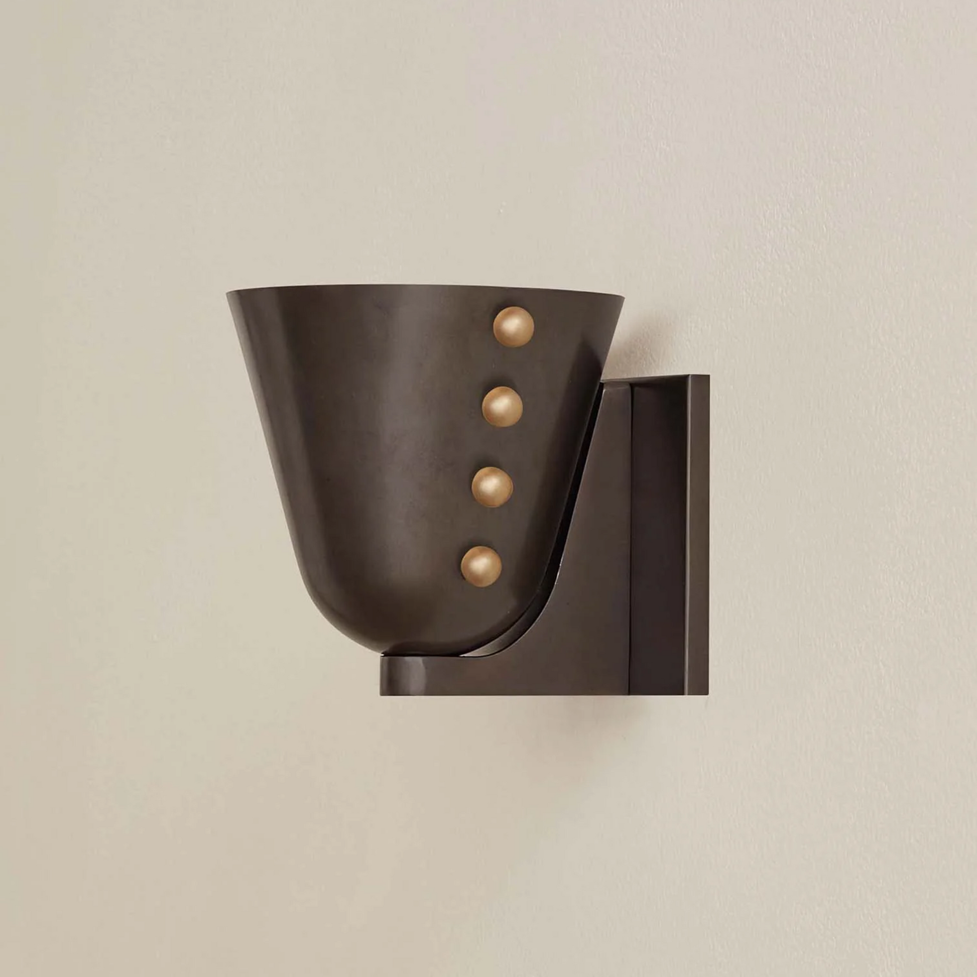 Modern wall sconce with three spherical elements on a beige background