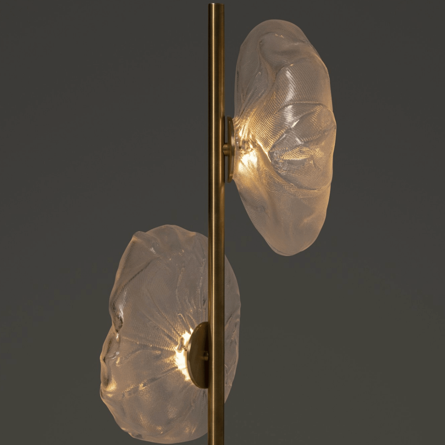 Wall-mounted light fixture with gold frame and textured glass shades on a dark background