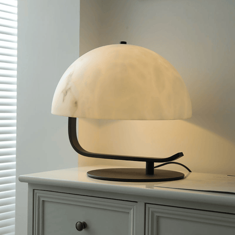 Table lamp with a marble-like shade on a white surface