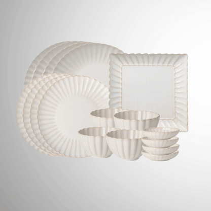 Set of white dinnerware with gold trim on a light gray background