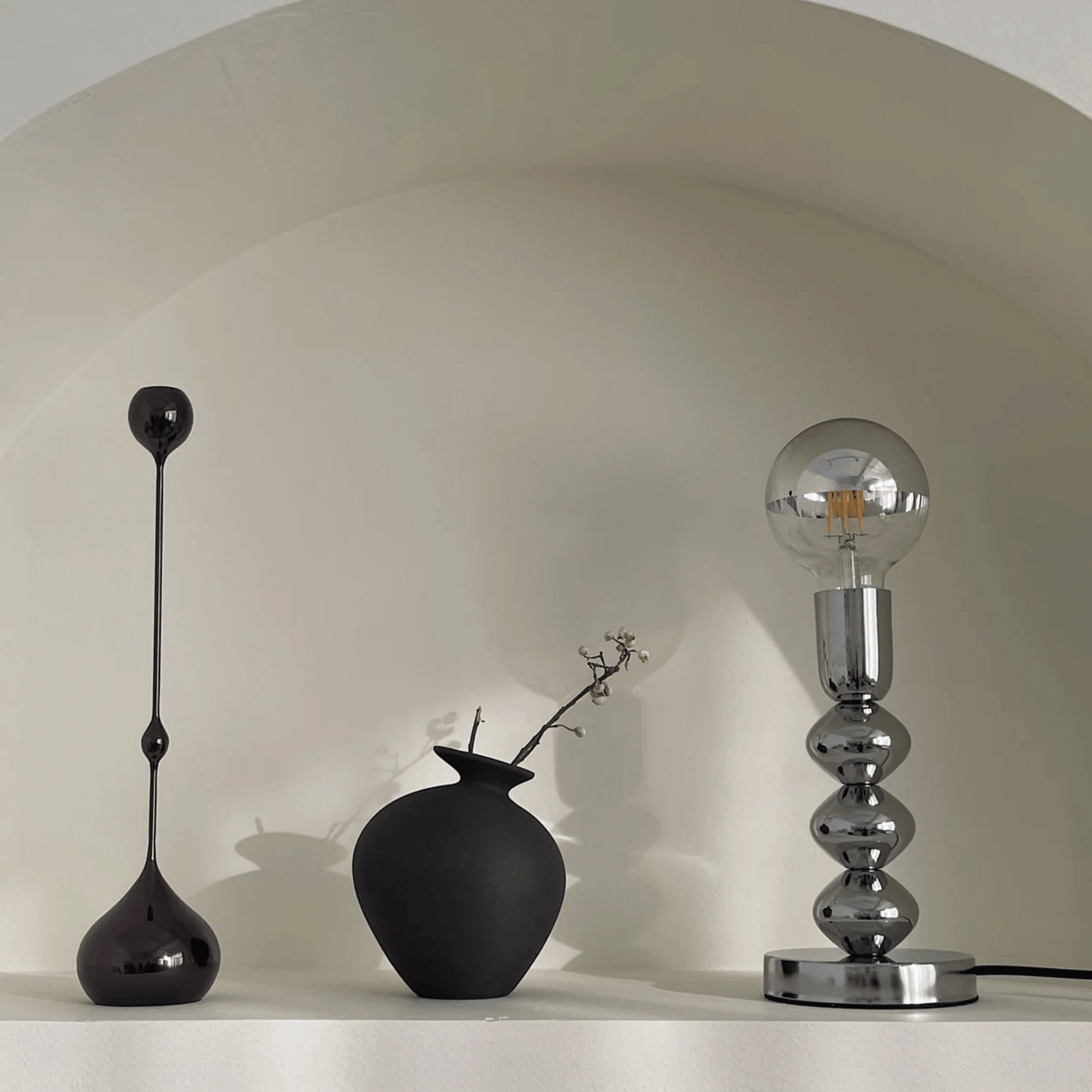 Three decorative lamps on a white surface with a neutral background