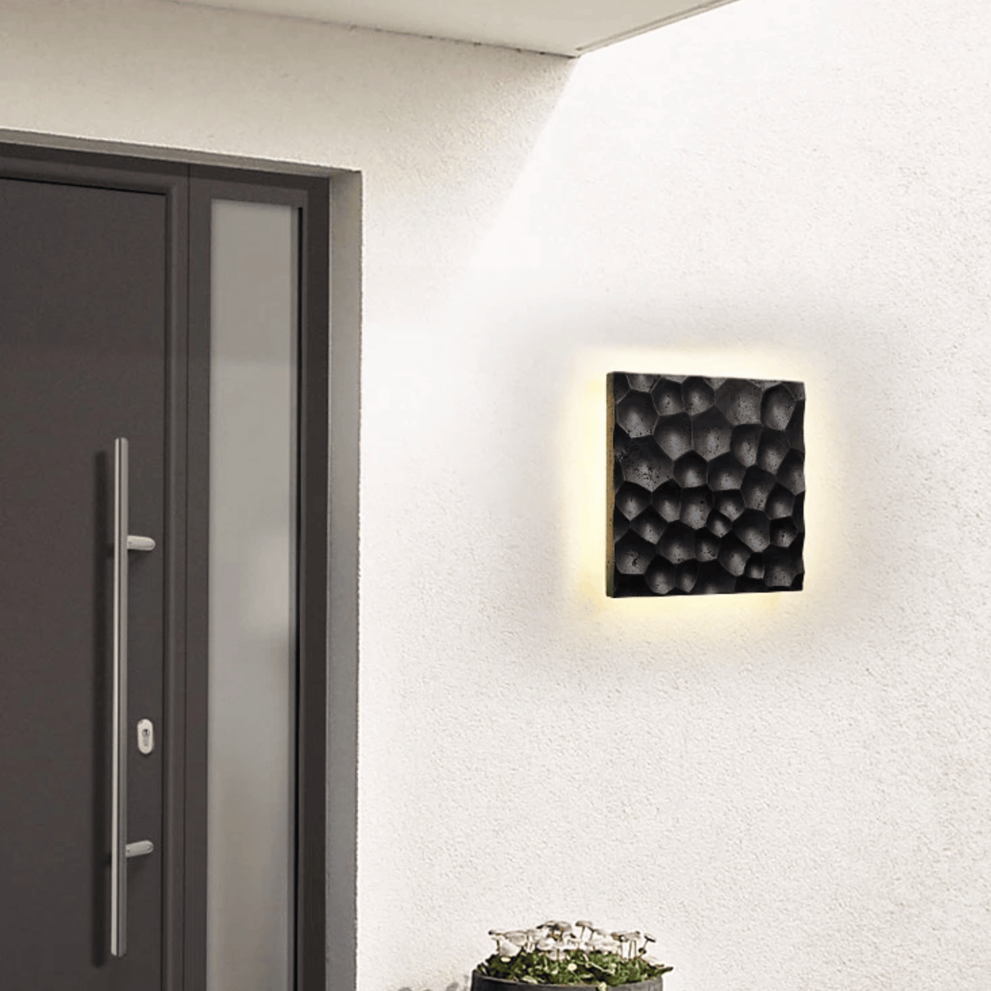 Modern wall-mounted light fixture on a white wall next to a door