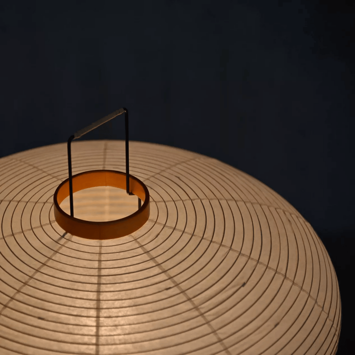 Close-up of a woven lampshade with a dark background