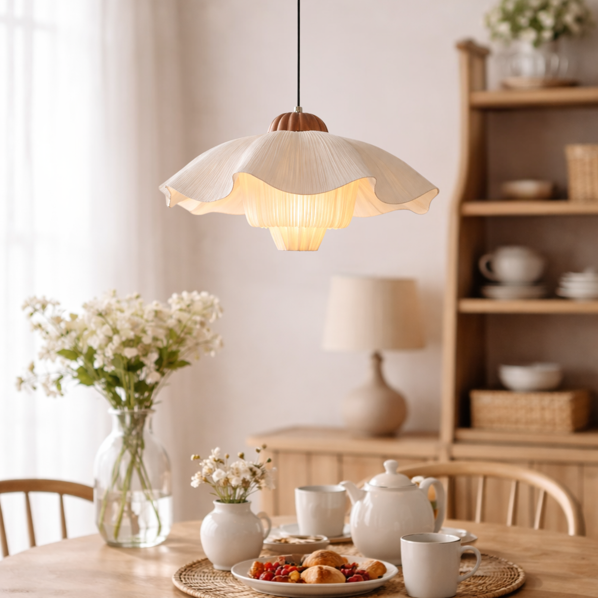 Dining room with a pendant light, table setting, and shelves in the background.