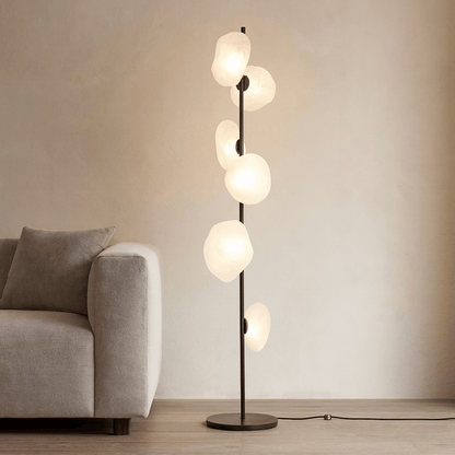 Modern floor lamp with multiple glass shades in a living room setting.