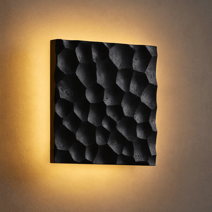 Square wall light with textured surface on a beige wall