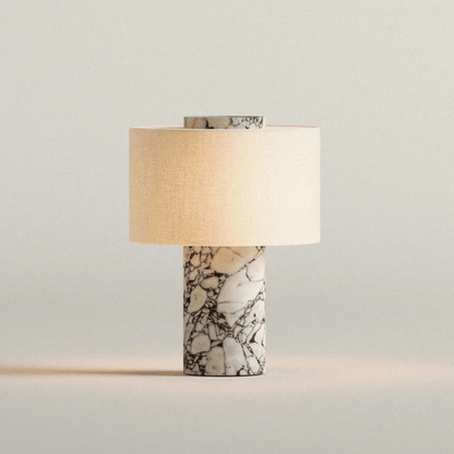Table lamp with marble base and beige shade on a light gray background