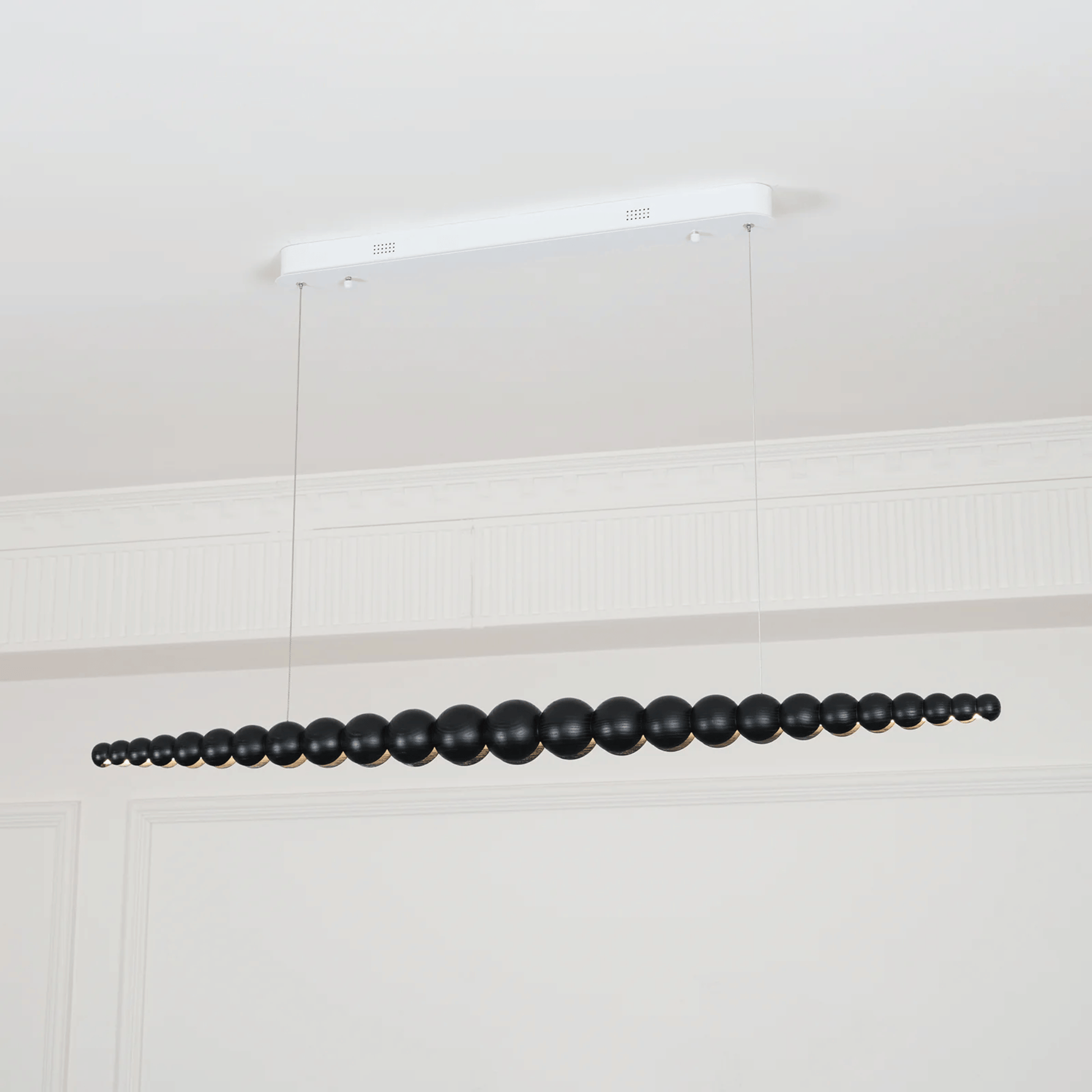 Black beaded chandelier hanging from a white ceiling