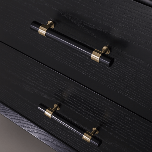 Black drawers with gold accents on a dark surface