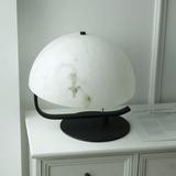 Decorative lamp with marble-like shade on a white surface