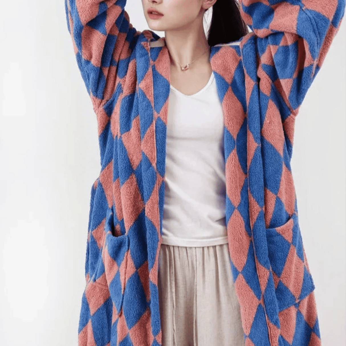 Person wearing a blue and red patterned cardigan on a white background