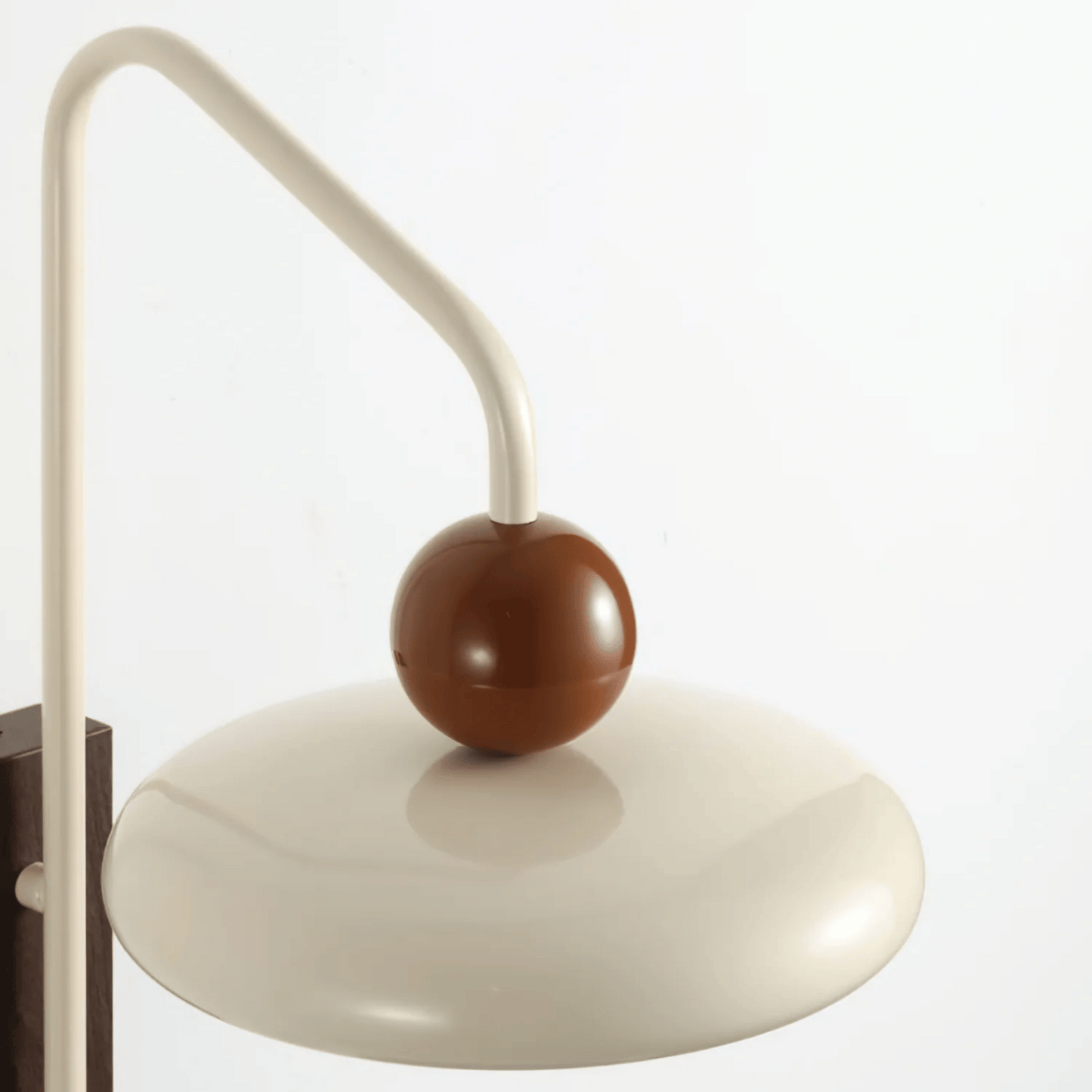 Decorative wall lamp with a brown sphere and beige arm on a white background