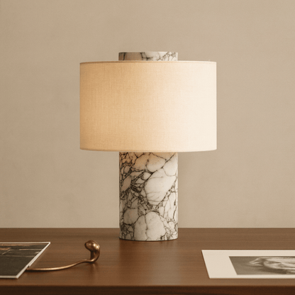 Table lamp with marble base on a wooden surface against a beige wall