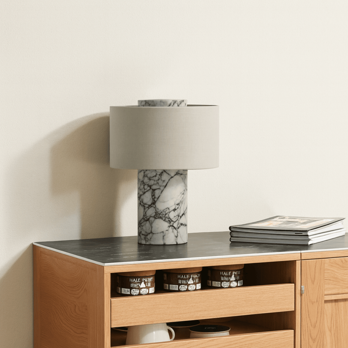 Wooden sideboard with marble lamp and books on a neutral background