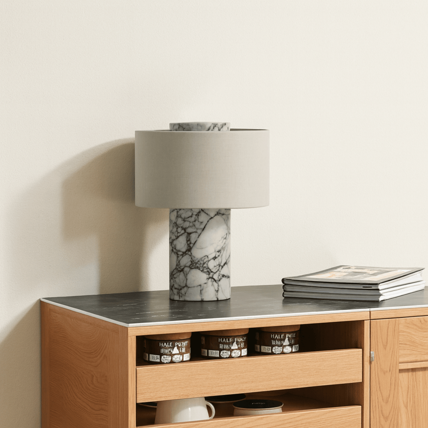 Wooden sideboard with marble lamp and books on a neutral background