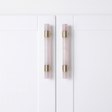 White cabinet doors with pink and gold handles on a white background