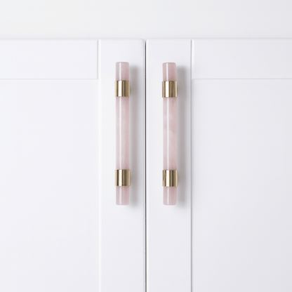 White cabinet doors with pink and gold handles on a white background