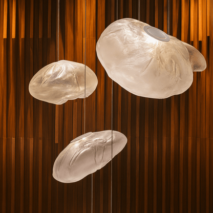 Three cloud-shaped pendant lights hanging against a wooden panel background