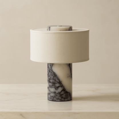 Table lamp with marble base and white shade on a beige surface