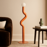 Modern floor lamp with wavy design in a living room setting.