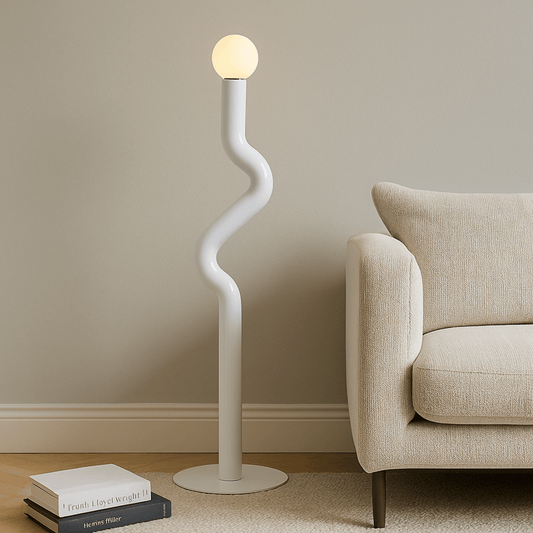 Modern floor lamp with a curved design next to a beige sofa in a living room.