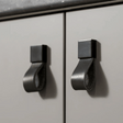 Metallic cabinet handles on a light gray cabinet door