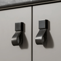 Metallic cabinet handles on a light gray cabinet door