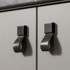 Metallic cabinet handles on a light gray cabinet door