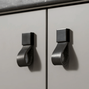 Metallic cabinet handles on a light gray cabinet door