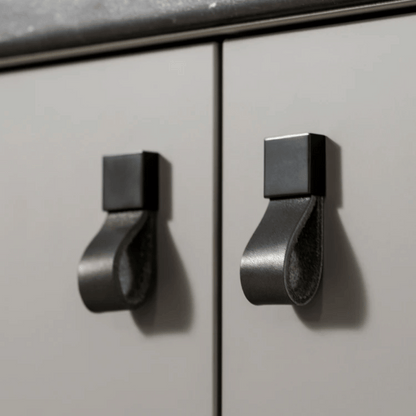 Metallic cabinet handles on a light gray cabinet door