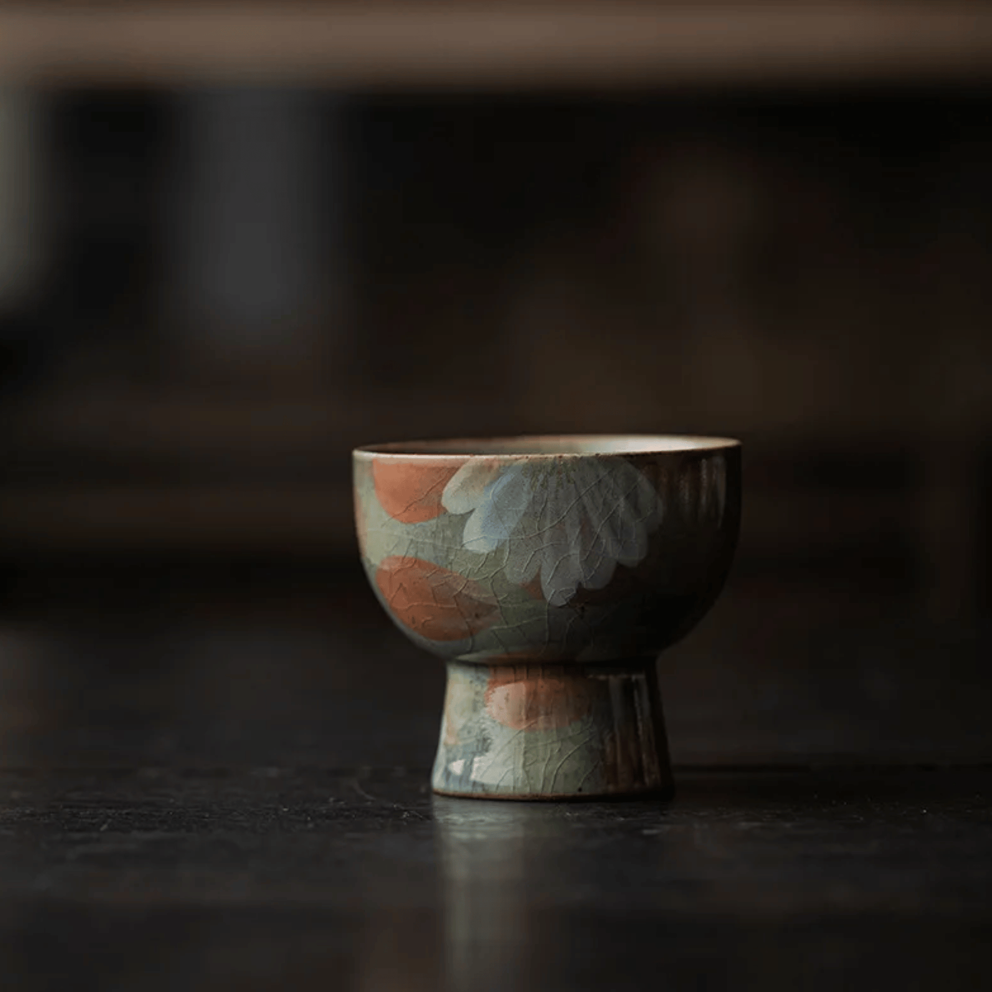 Ceramic cup with floral patterns on a dark surface