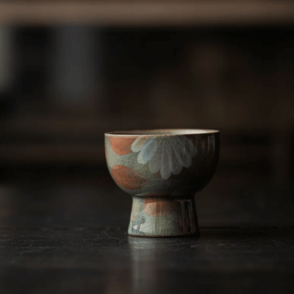 Ceramic cup with floral patterns on a dark surface