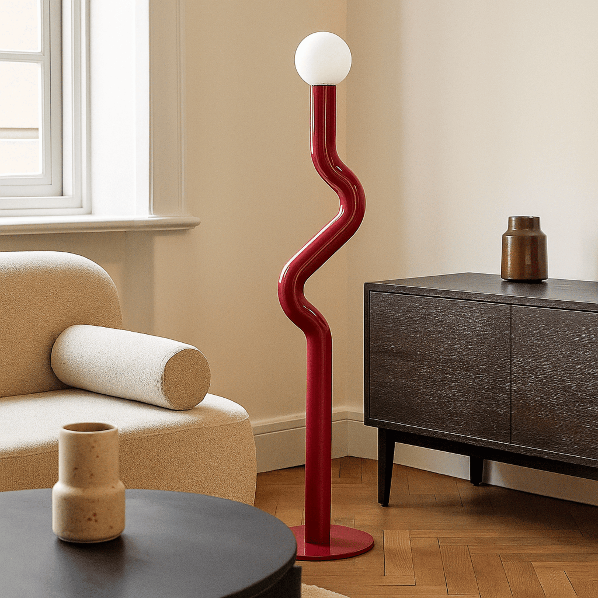 Modern red floor lamp in a living room setting with a beige armchair and wooden sideboard.