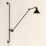 Black wall-mounted lamp with adjustable arm on a beige background