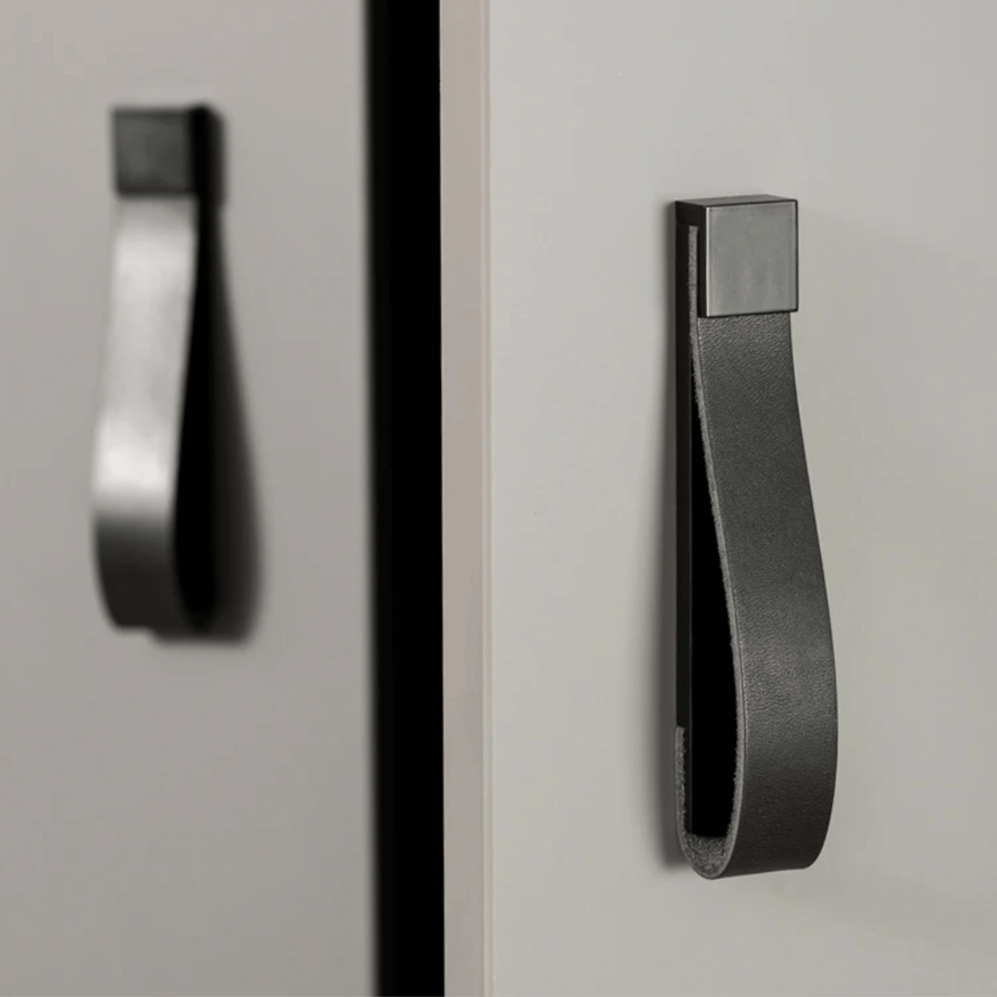 Black cabinet handle on a gray cabinet door