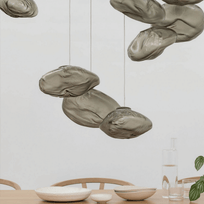 Decorative pendant lights hanging above a dining table with a neutral background