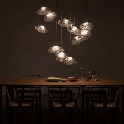 Dining table with chairs and a modern chandelier in a dimly lit room