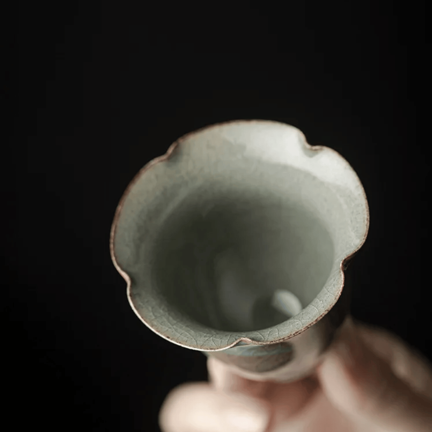 Ceramic cup with a textured interior held against a dark background