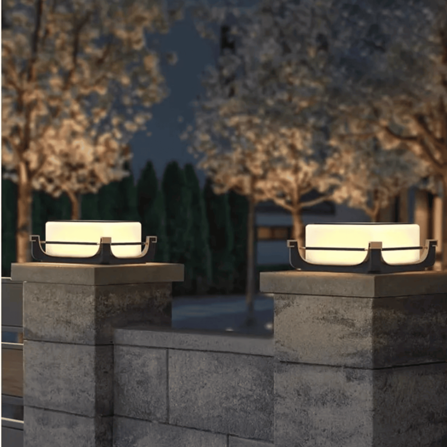 Two outdoor lights on stone pillars with a blurred background of trees and sky.