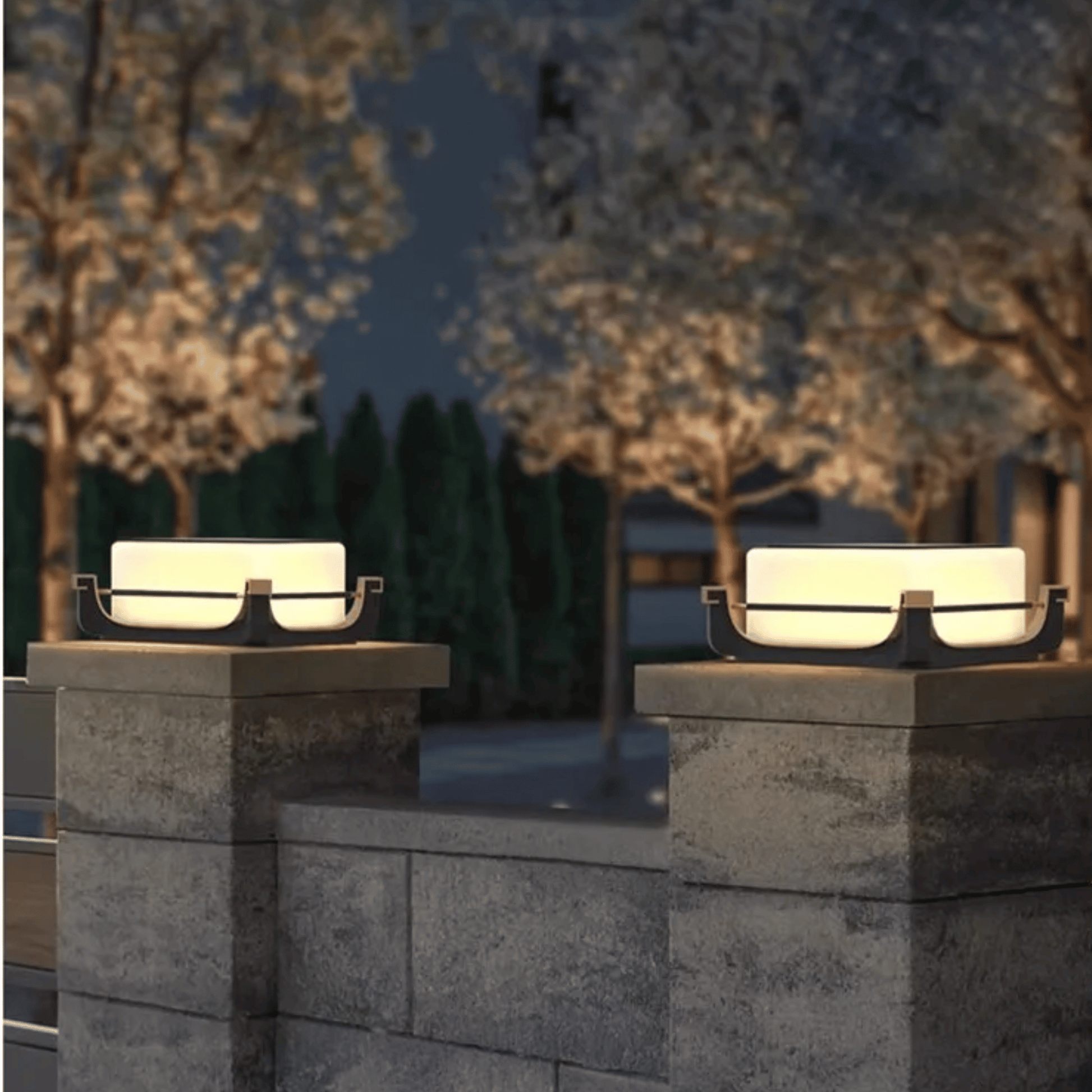 Two outdoor lights on stone pillars with a blurred background of trees and sky.
