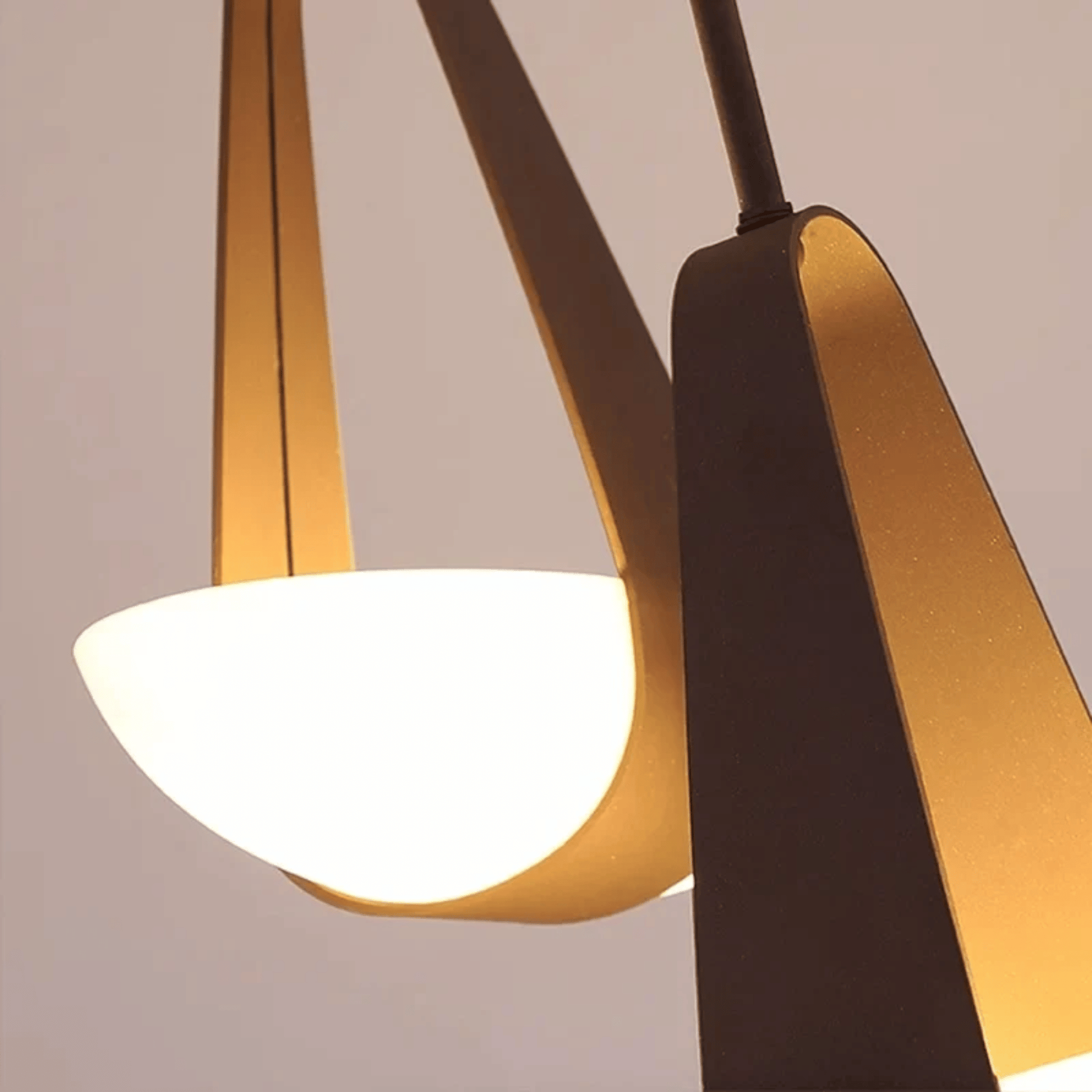 Modern pendant light with gold and black design on a neutral background