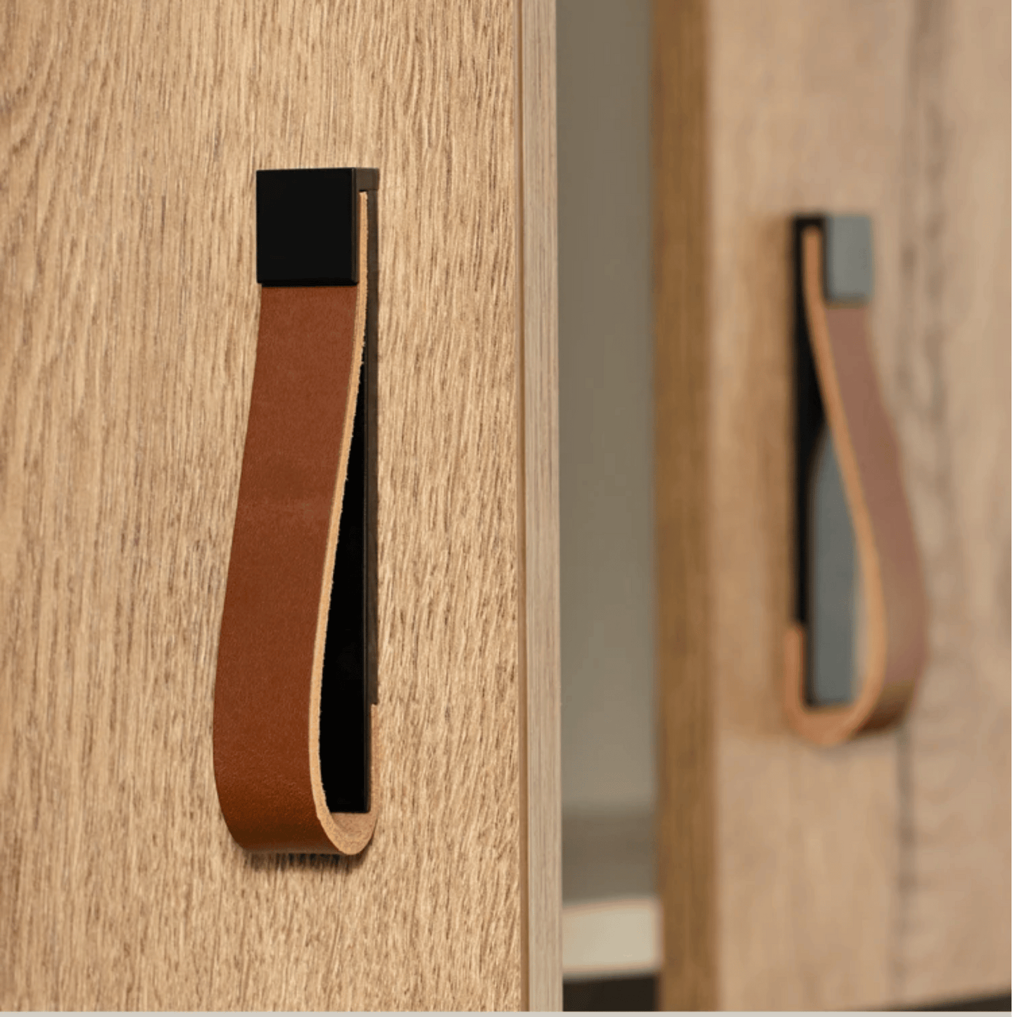 Close-up of wooden furniture with leather handles on a light wood background