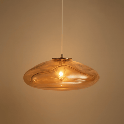Amber glass pendant light against a beige background